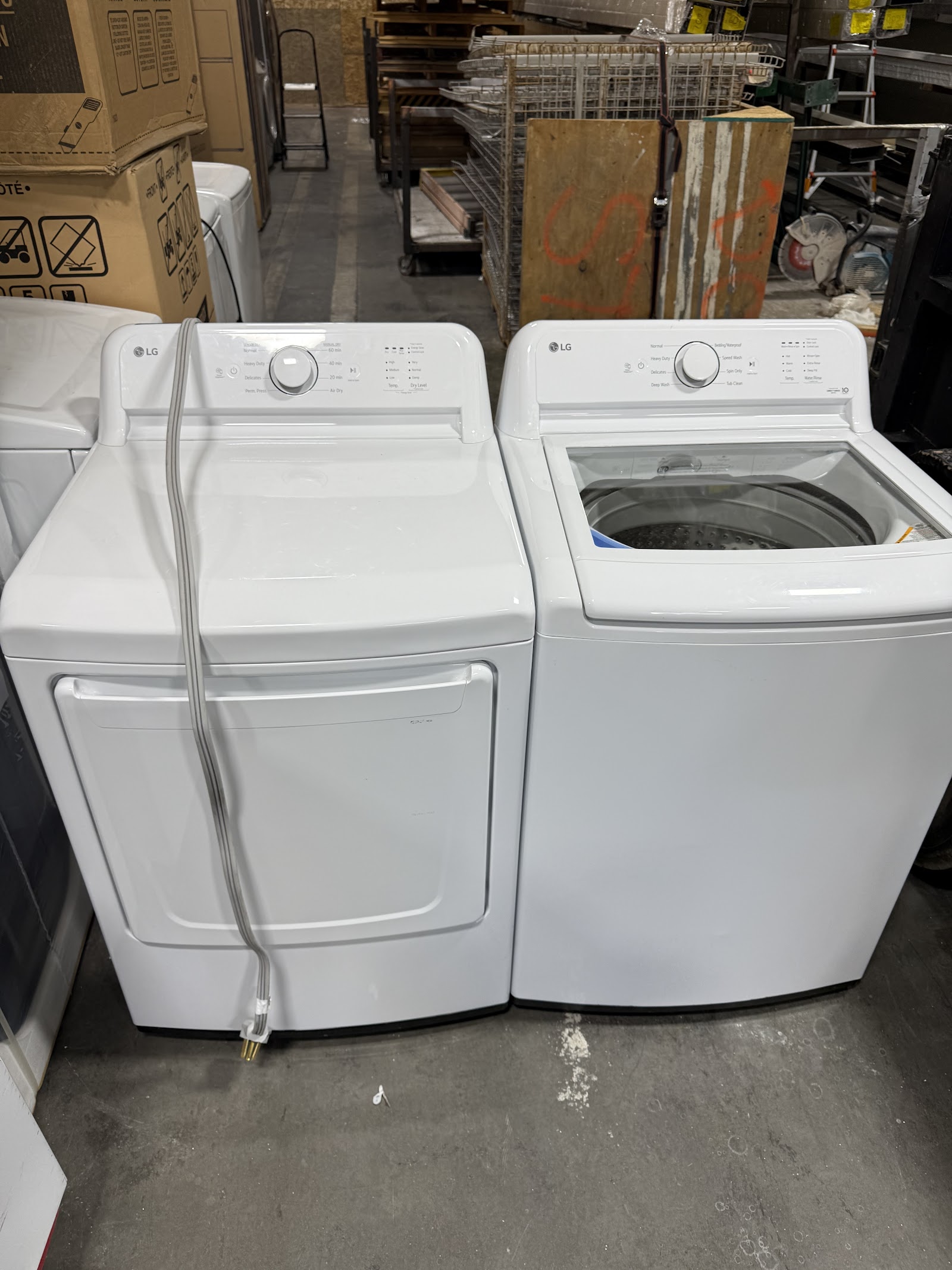 Pair of white LG top-load washer and dryer in the warehouse