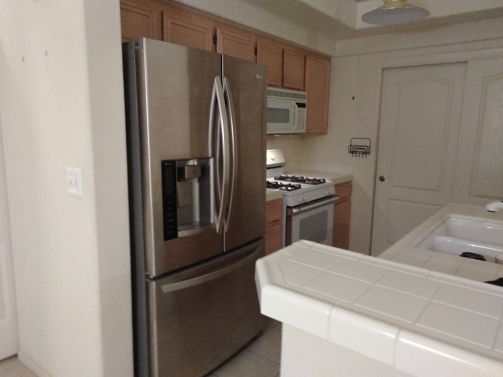 Kitchen with a stainless LG French-door refrigerator and a white gas range